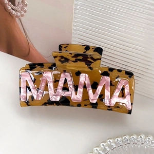 Détail d'une pince à cheveux écaille de tortue avec lettres MAMA en marbre rose