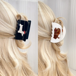 Cute animal acetate hair claws with puppy and bear motifs shown on long hair