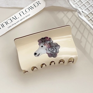 Close-up of cream rectangle hair claw with purple textured poodle design on beige background