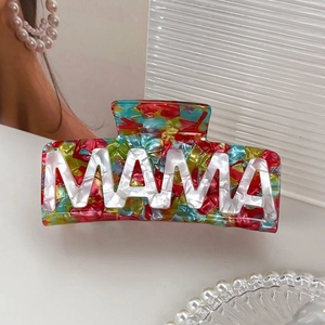 Détail du lettrage MAMA sur une pince à cheveux en acétate au motif mosaïque coloré