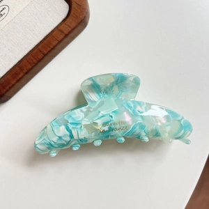 Detail of mint green marble cellulose acetate hair claw clip with golden lettering