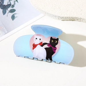 Detail shot of light blue cat hair claw clip with heart illustration and scarf cats