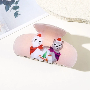 Detail of light pink acetate hair claw clip featuring cute Christmas cats and Merry Christmas text