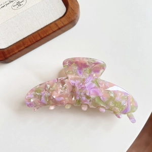 Detail of large marble resin hair claw clip with pink and purple floral patterns
