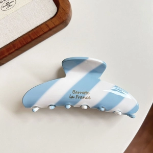 Detail showing blue and white striped hair claw clip with golden Barrette La France text