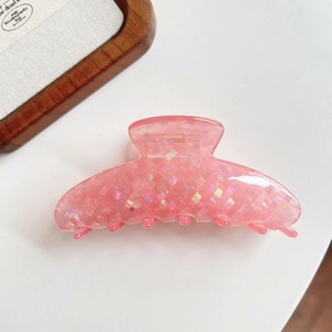 Detailed close-up of a pink resin hair claw clip with colorful iridescent glitter sequins