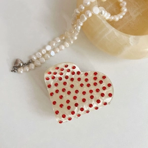 Vue macro détaillée de la pince à cheveux en forme de cœur avec strass rouges