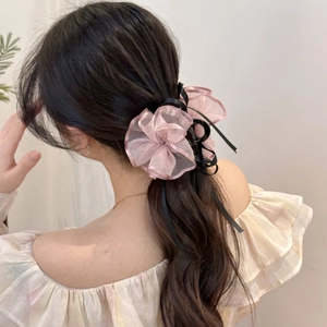 Elegante fermaglio per capelli con fiore in organza rosa e nastri neri sulla modella