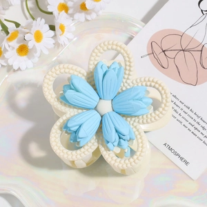 Detail einer hellblauen Blumen-Haarklammer mit mattem Finish auf einem Tablett