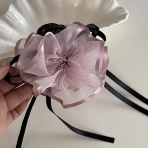 Dettaglio della grande molletta per capelli in organza lavanda con nastri di seta neri