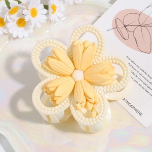 Detail der Blumen-Haarklammer mit cremefarbenen Blüten und gelber Perlenstruktur
