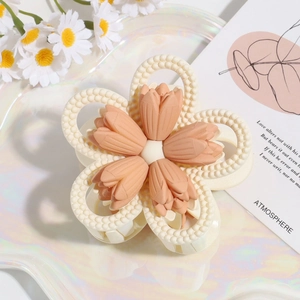 Detailansicht einer Blumen-Haarklammer in Beige und Korallenrosa mit mattem Finish