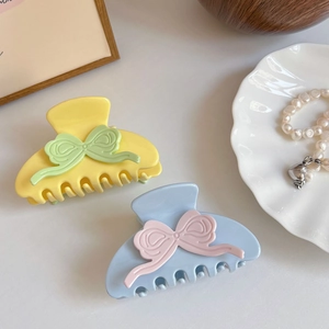 Cute bow-shaped acetate hair claw clips in colorful pastel shades for women's hairstyling