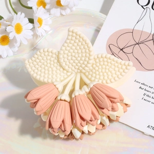Detalle de pinza para el pelo con forma de flor de lirio rosa y elegante acabado mate