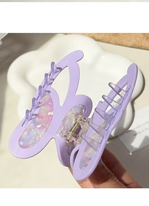 Detailed macro view of a light purple butterfly hair claw clip with colorful iridescent glitter