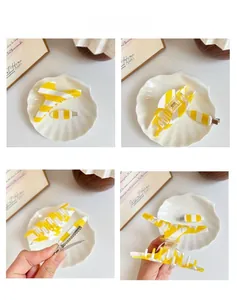 Detail view of yellow striped acetate hair claw clips and small hairpins set