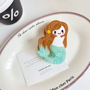 Detail of mermaid hair claw clip made of acetate on a white ceramic plate