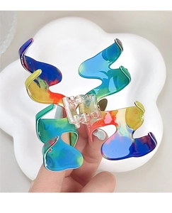 Détail de la pince à cheveux dégradé arc-en-ciel avec design acrylique coloré en forme de M