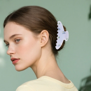 Blue and yellow floral hair claw clip worn on a bun for a fresh and elegant look