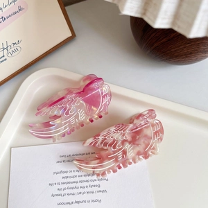 Pink acetate bird-shaped hair claw clips with marble pattern and elegant wing details