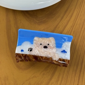 Haarklammer aus Acetat mit niedlichem Hundemuster und Wolken auf Holzhintergrund