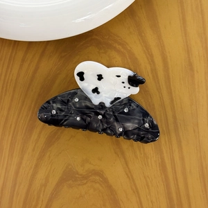Elegant acetate hair claw clip with black marble texture and cow print heart design