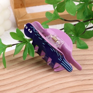 Détail de la pince à cheveux dinosaure en acrylique bleu et violet avec ressort argenté
