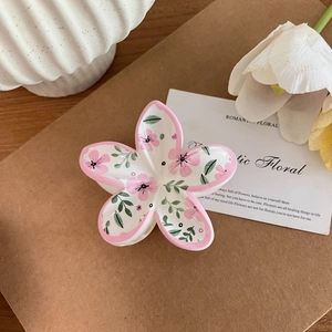 Detailansicht einer Blumen-Haarklammer mit rosa Blütenmuster auf weißem Hintergrund