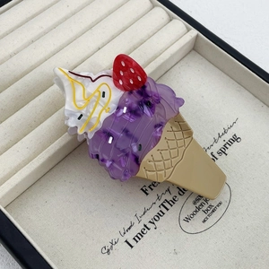 Detailed close-up of an ice cream shaped hair claw clip in a velvet jewelry display box