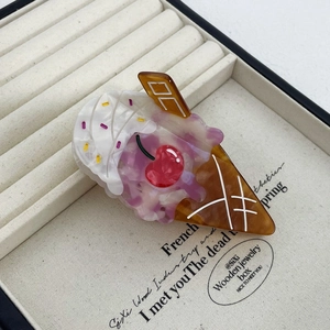 Detail view of ice cream cone hair claw clip made of acetate material in a jewelry box