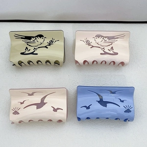 Set of four acetic acid hair claws with bird patterns in green, cream, pink, and blue colors