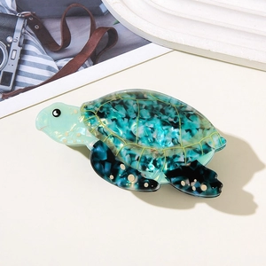 Detailed macro of turtle hair claw clip made with marbled blue and green acetate material