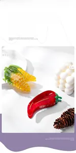 Detailed close-up of vibrant corn and chili pepper shaped hair claws made of acetate resin
