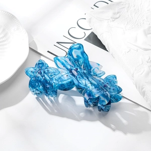 Pince à cheveux fleur en acétate bleu marbré élégante ornée de strass brillants