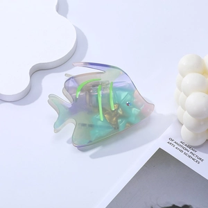 Détail macro d'une pince à cheveux poisson en acétate dégradé avec des strass étincelants