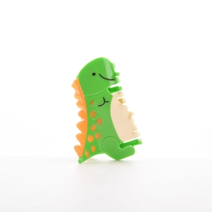 Vue détaillée d'une pince à cheveux dinosaure verte avec nageoires dorsales oranges