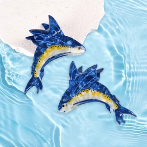 Dettaglio di fermacelli per capelli a forma di pesce vela blu e giallo marmorizzato