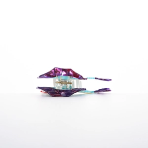 Detail view of tropical fish hair claw with purple marble pattern and metal spring