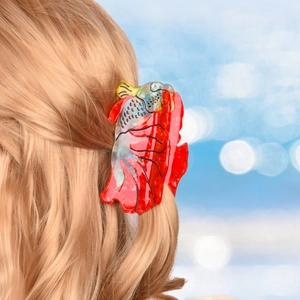 Elegant red fish-shaped acetate hair claw clip with rhinestones worn by a model