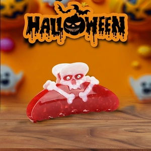 Detail of red translucent acetate hair claw with rhinestones and skull design for Halloween