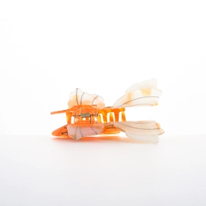 Detail view of tropical fish hair claw clip showing orange acetate resin and metal spring