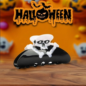 Detail view of acetate skull and crossbones hair claw clip with rhinestones for Halloween