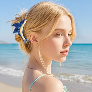 Pinza per capelli a forma di pesce blu e gialla indossata da una modella in spiaggia