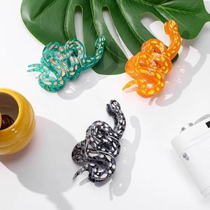 Trois pinces à cheveux serpent en acétate vertes, orange et grises avec motifs à pois