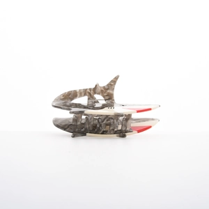 Macro detail of tropical shark hair claw clip with grey marble texture and red accents