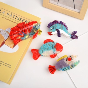 Macro detail of assorted acetate fish hair claws with colorful marble textures and rhinestones