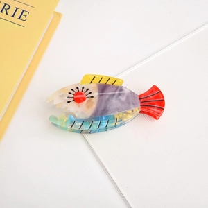 Detailed macro view showing the colorful acetate texture and fish fin design of the hair claw
