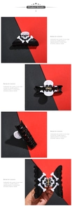 Detail view of large black skull hair claw clip with crossbones and metal spring