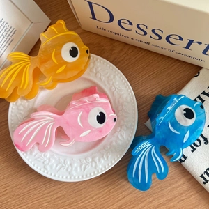 Three colorful acetate goldfish hair claws in orange, pink, and blue for elegant styling