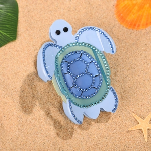 Pince à cheveux tortue de mer bleu clair avec strass sur un fond de plage tropicale
